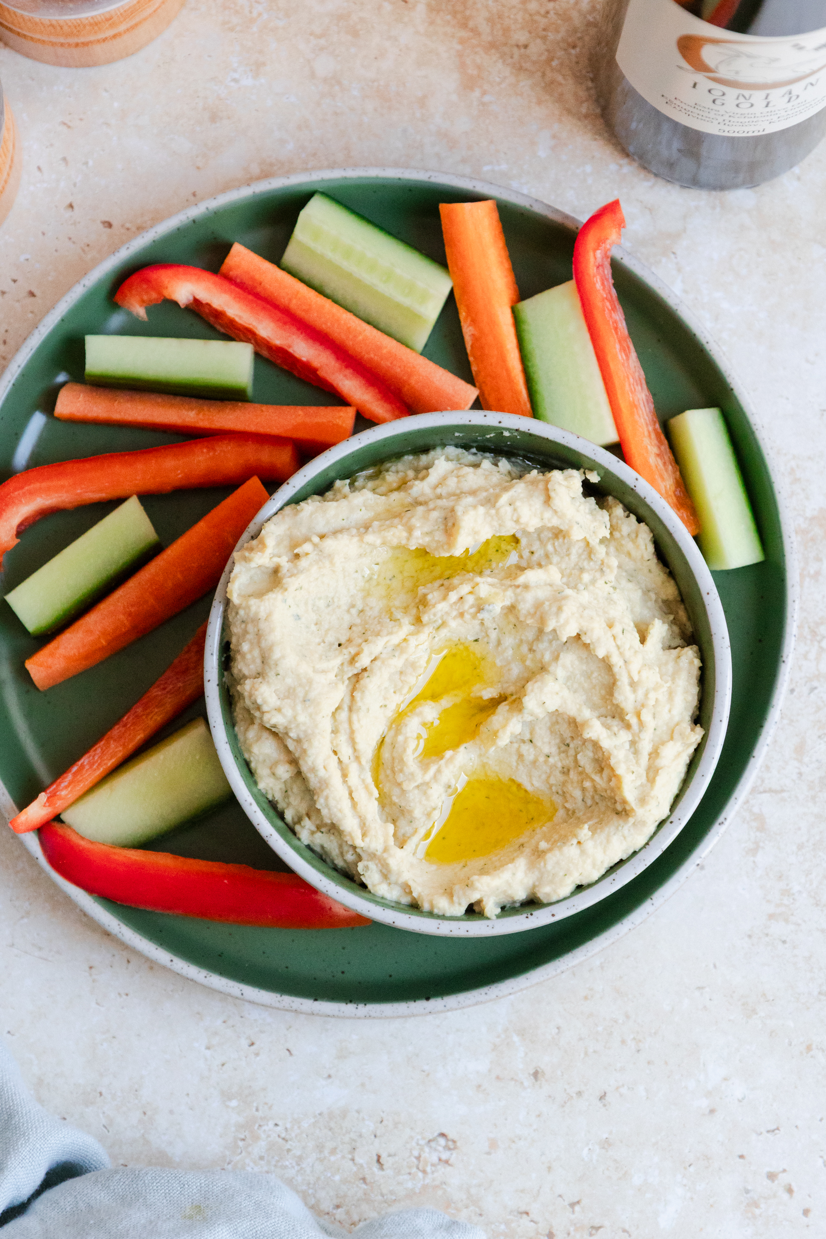 pickle houmous topped with olive oil and surrounded by vegetable sticks